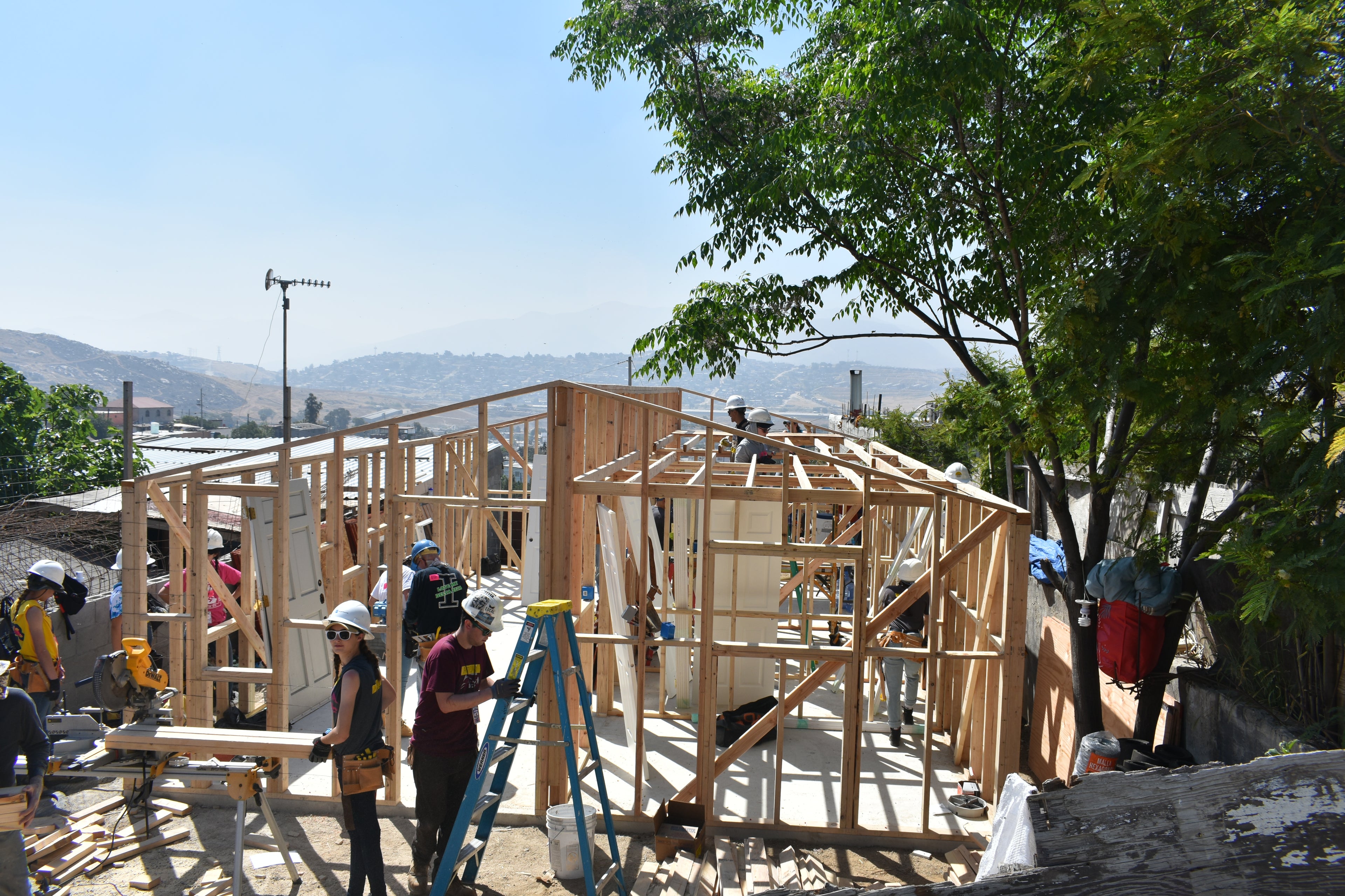 Construction site with wooden frame and workers on a clear day